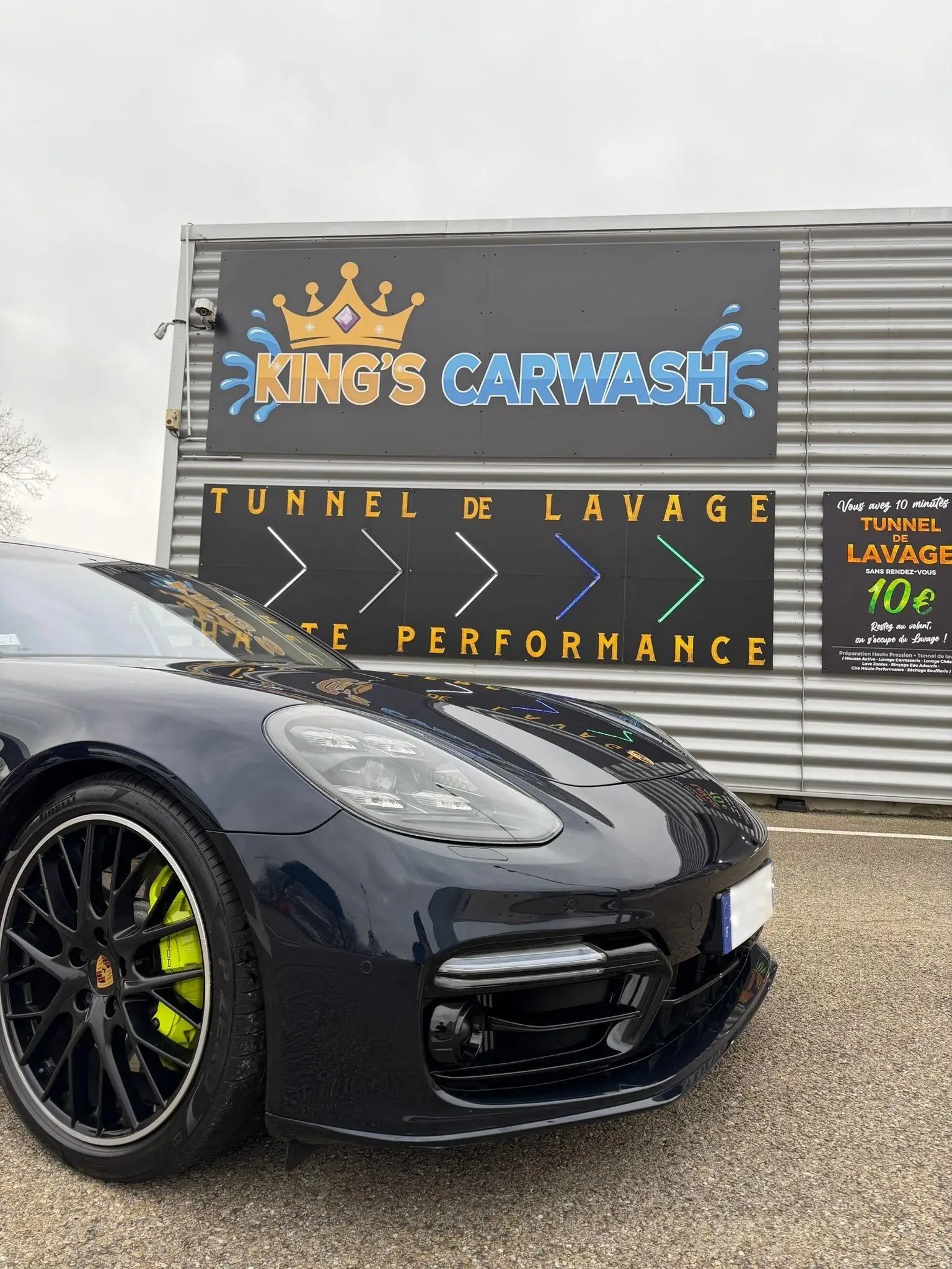 Porsche Panamera devant l’enseigne King’s CarWash, tunnel de lavage à Nîmes